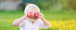 toddler with apples over his eyes